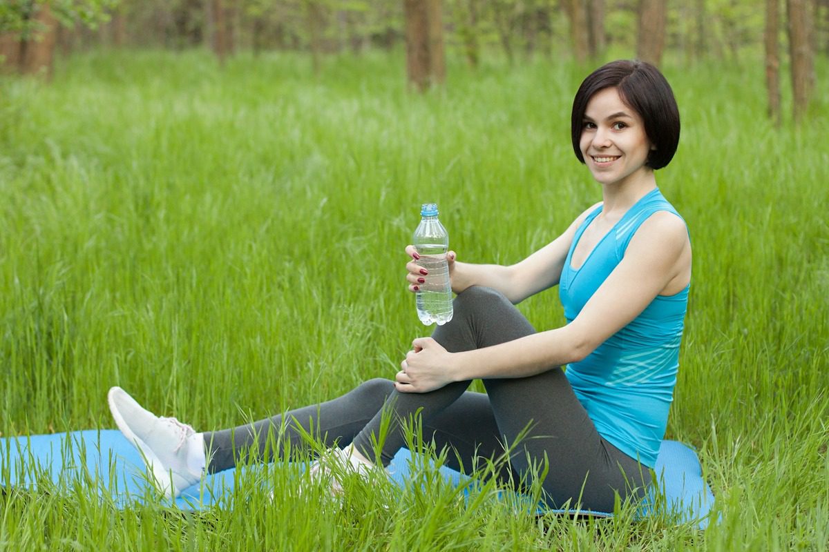 lady resting after walk out in a serene environment, holding water